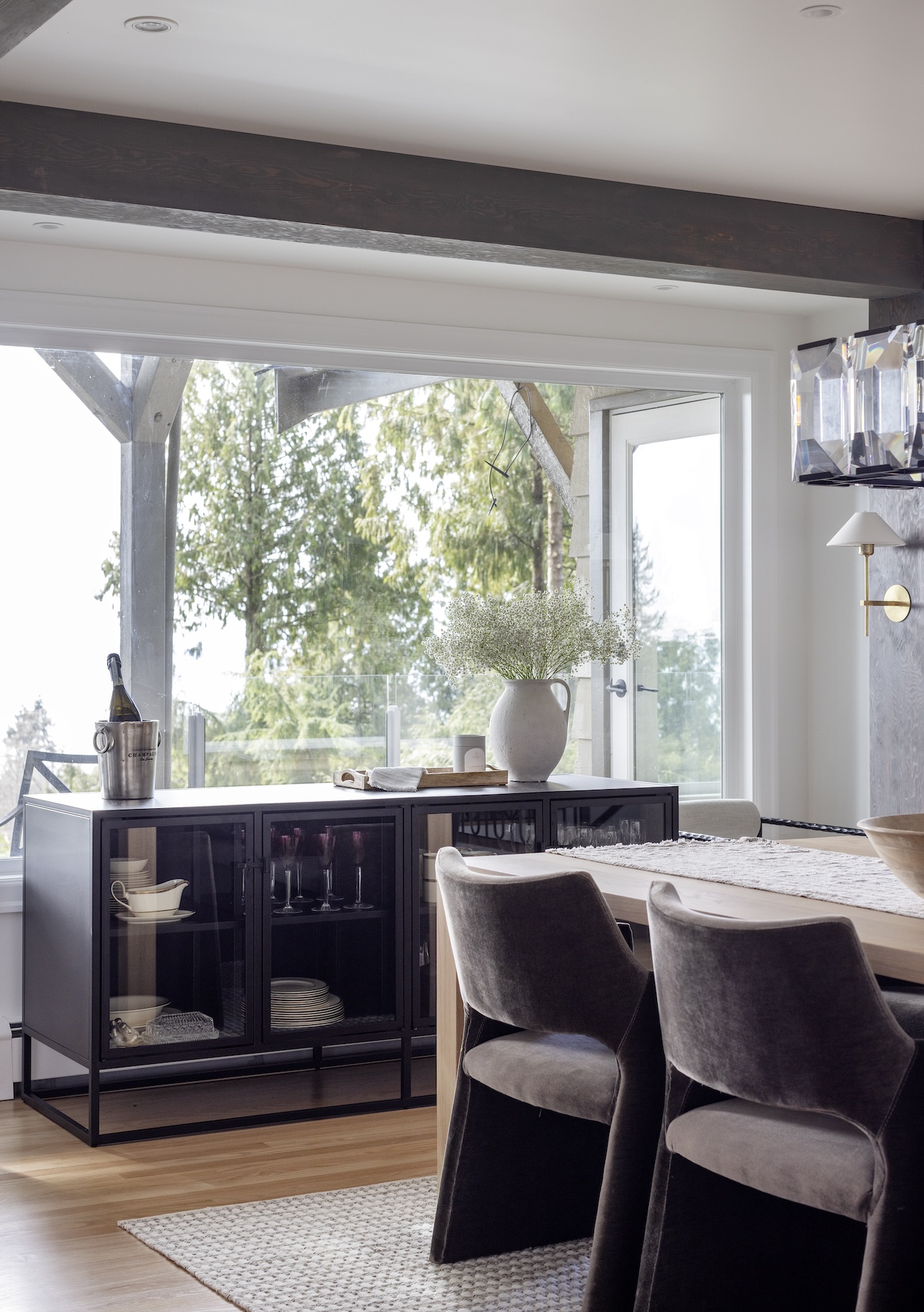 megan baker interiors luxury interior design west coast reno slice of a dining room with black metal hutch and glass doors to display china modern velvet chairs and textured rug on white oak floor