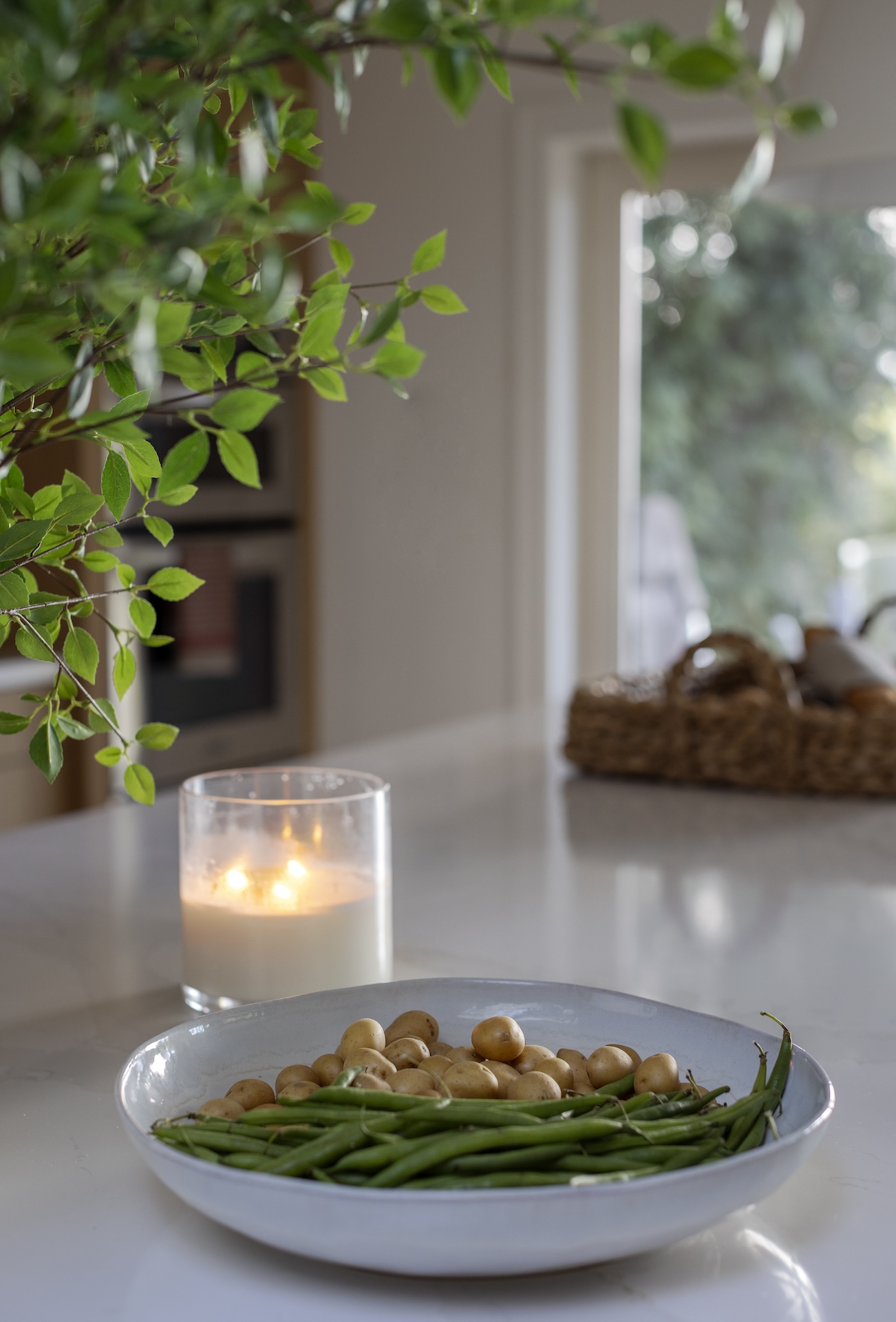 megan baker interiors luxury interior design west coast reno detaile of a handcrafted bowl on the counter with potatoes and green beans and a candle lit in the background