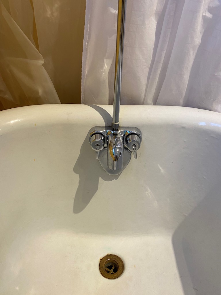 BATHROOM BEFORE & AFTER: The antique clawfoot tub with old plumbing fixtures